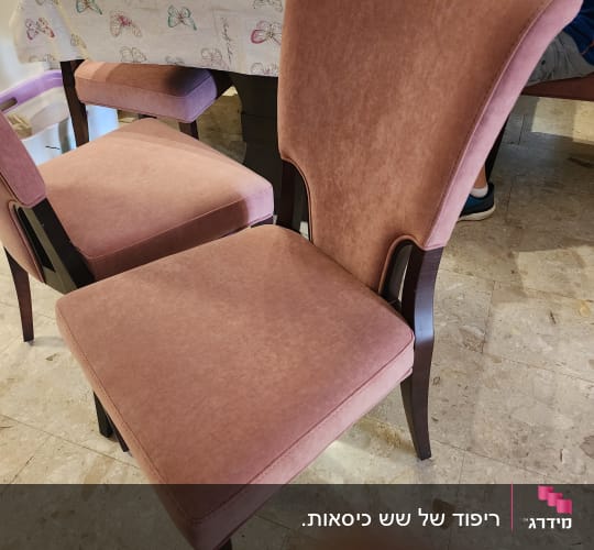 כיסאות מרופדים בבד ורוד ליד שולחן אוכל